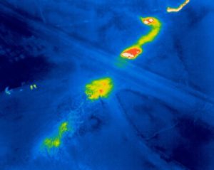 Obr. 3:  Lokalizace místa úniku teplé vody z podzemního teplovodu. Vlevo jsou patrné drobné postavy operátorů bezpilotního letadla provádějící letecké snímkování